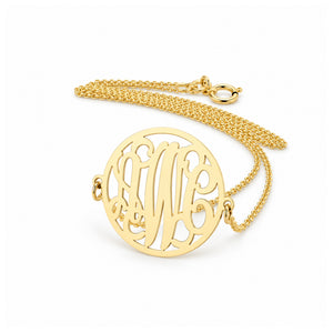 Small solid gold three-initial circle monogram necklace on white background