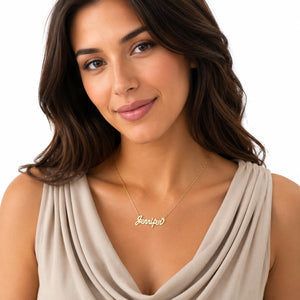 A woman wearing a delicate gold script necklace with the name 'Jennifer' on a white background.
