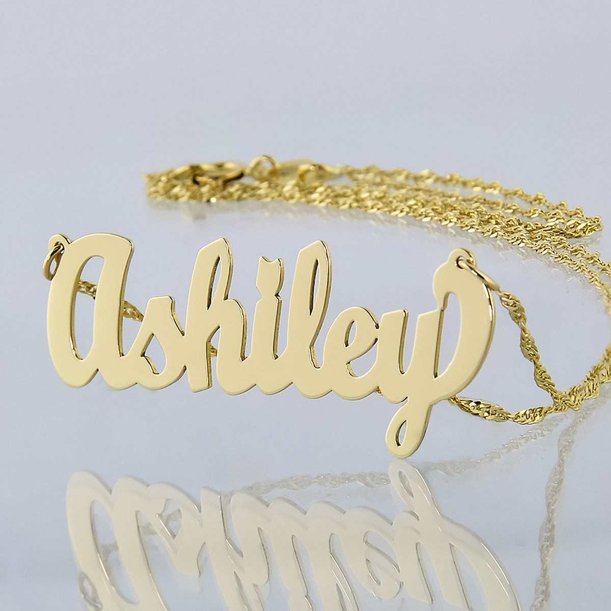 Custom solid 10k yellow gold script small nameplate necklace spelling Ashley on a Singapore gold chain.