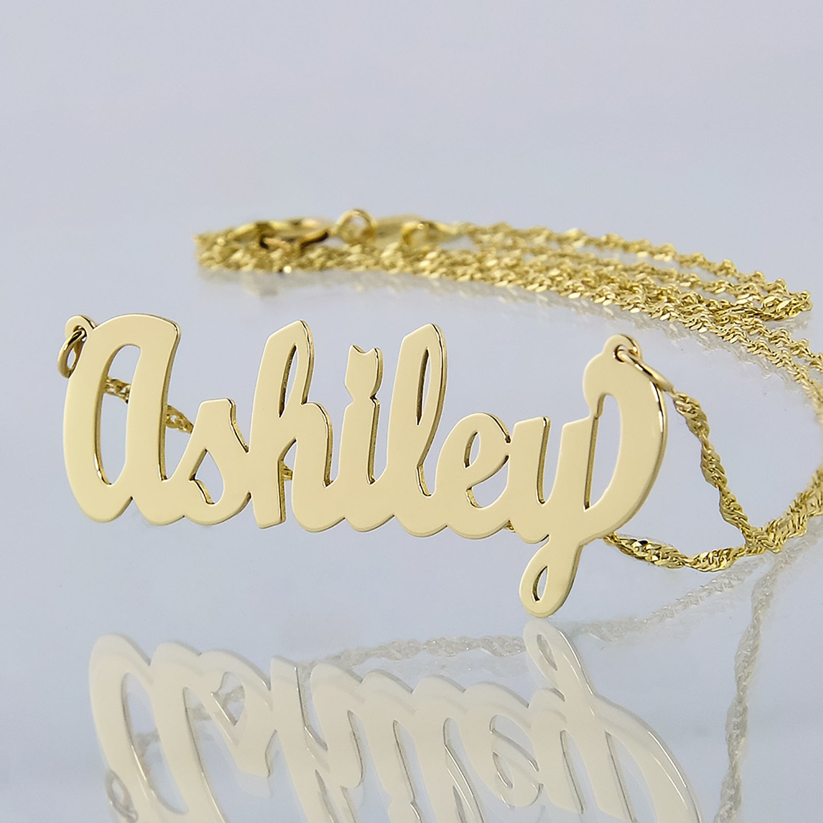 Custom solid 10k yellow gold script small nameplate necklace spelling Ashley on a Singapore gold chain.