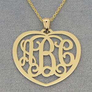 Yellow gold 3-initial heart monogram pendant necklace on a textured gray background.