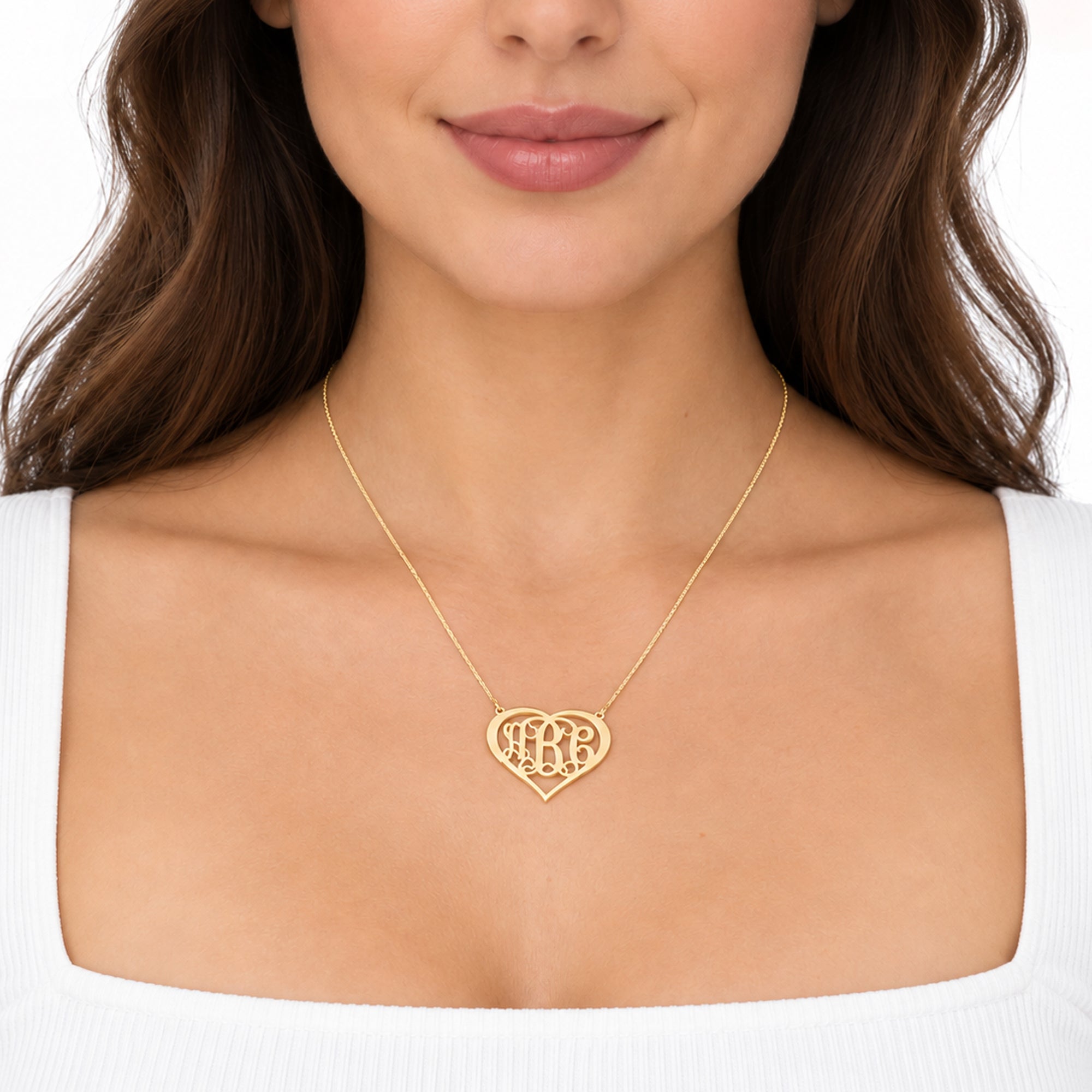 Model wearing a solid gold heart monogram necklace with a personalized three-initial pendant.
