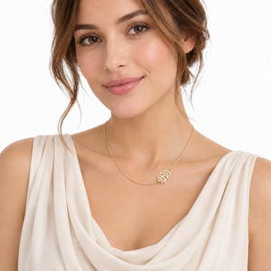 Close-up of a woman wearing a solid 14k yellow gold three-initial sideways monogram necklace