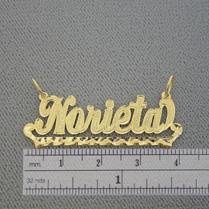 Handcrafted solid gold script nameplate pendant shown against a grid background displaying its 1.6-inch length measurement.