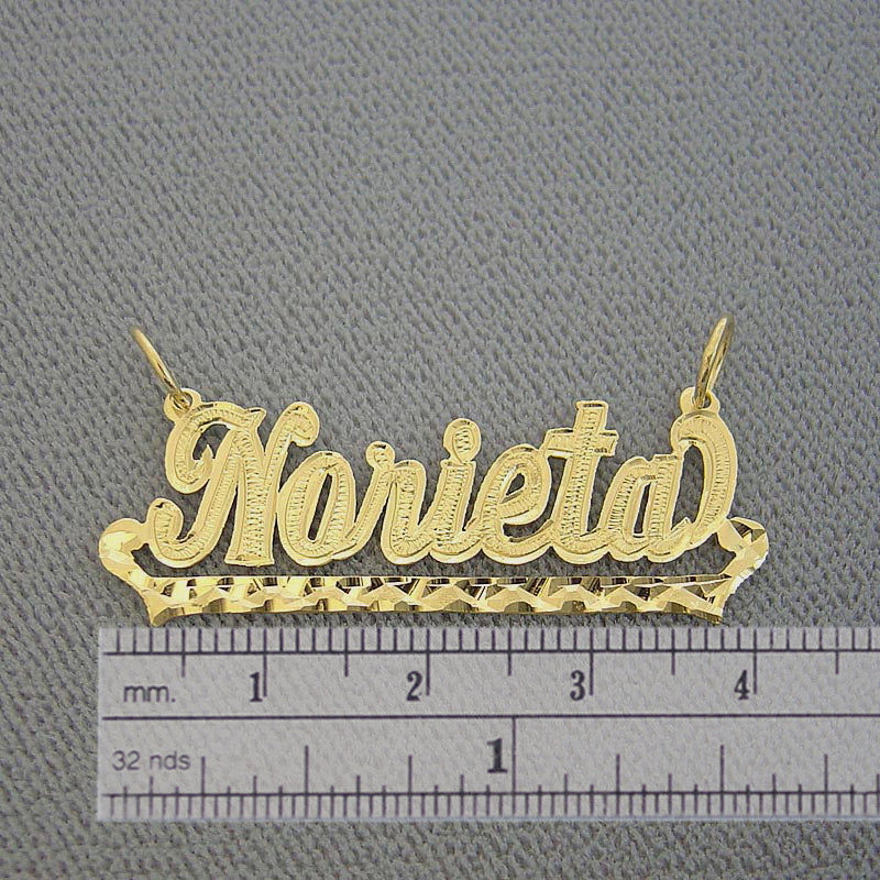 Handcrafted solid gold script nameplate pendant shown against a grid background displaying its 1.6-inch length measurement.