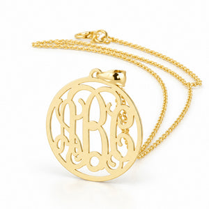 Three-initial solid gold circle monogram pendant on a matching gold chain.