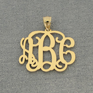Solid yellow gold three-initial custom monogram pendant displayed against a gray jewelry background.