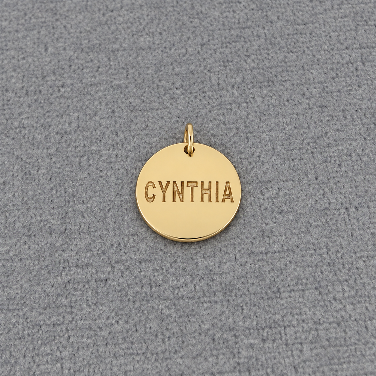 Solid white gold personalized round disc charm pendant laser engraved with the name Cynthia.