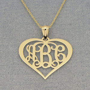 Detailed view of personalized solid gold heart monogram necklace with three initials