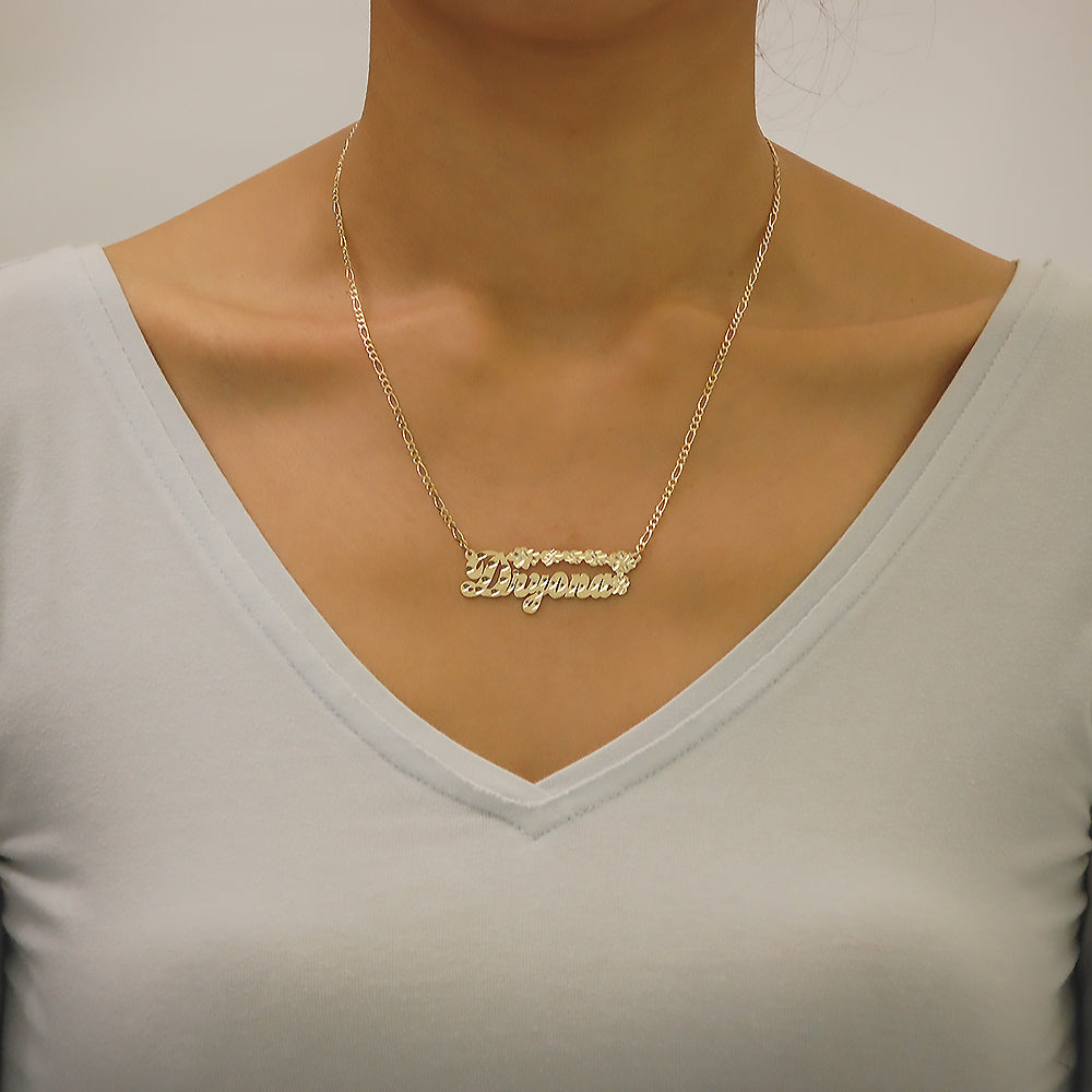 Close-up of a woman wearing a custom 10K solid gold personalized name necklace with diamond-cut floral details.