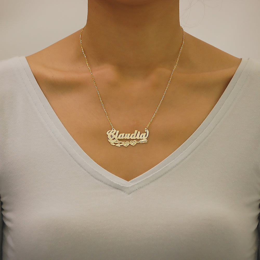 Woman wearing a custom 14K gold nameplate necklace featuring a Cupid's arrow motif with a V-neck shirt.