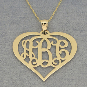 Detail view of a custom yellow gold 3-initial heart monogram pendant on chain