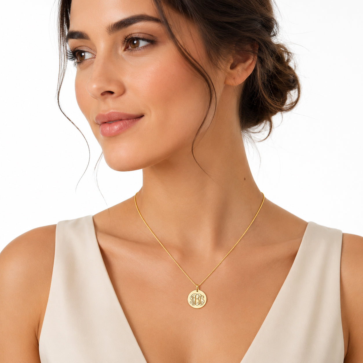 Yellow gold custom monogram engraved disc pendant charm displayed on a Rolo chain on the model.