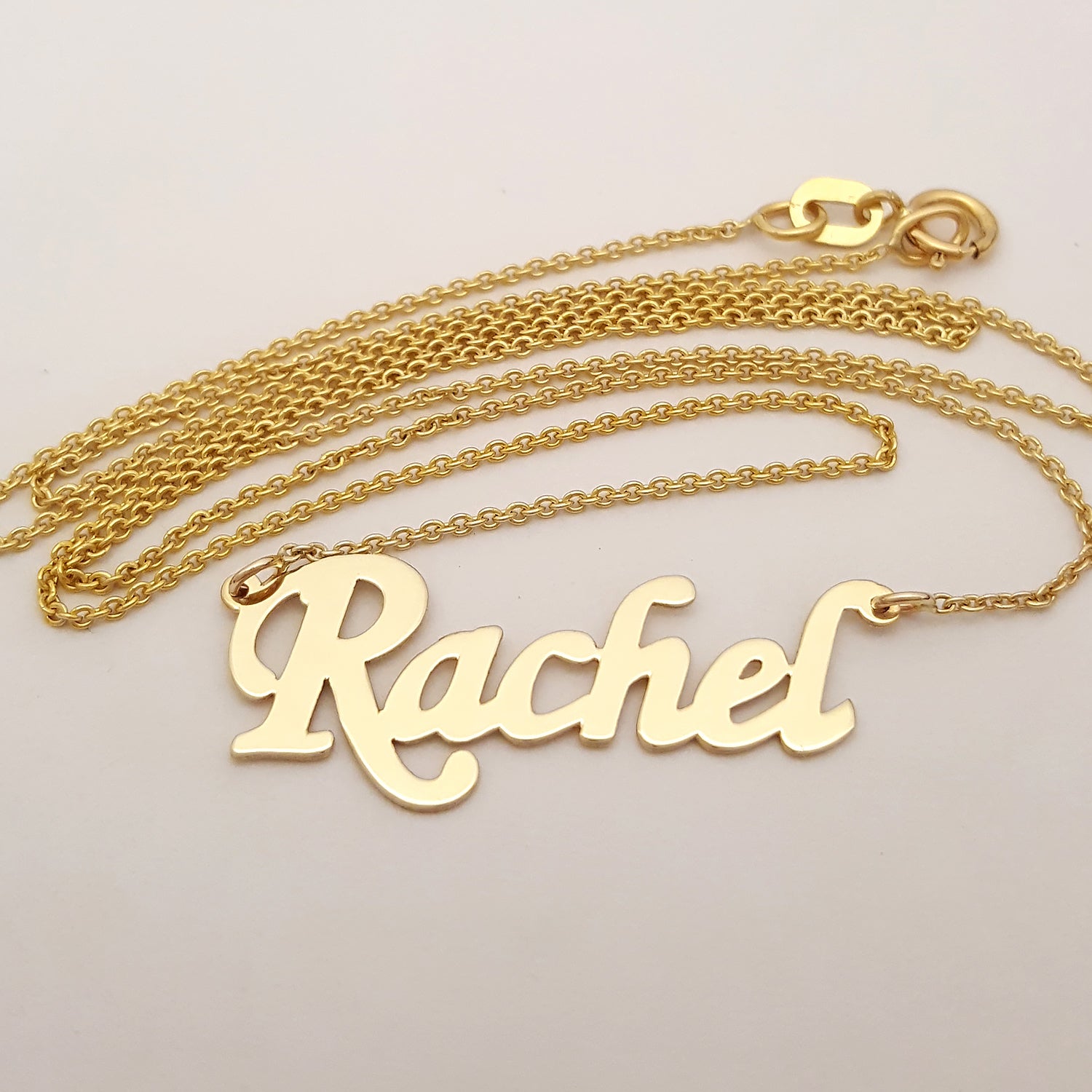 10k solid gold dainty custom Rachel nameplate necklace displayed on a classic Rolo chain.
