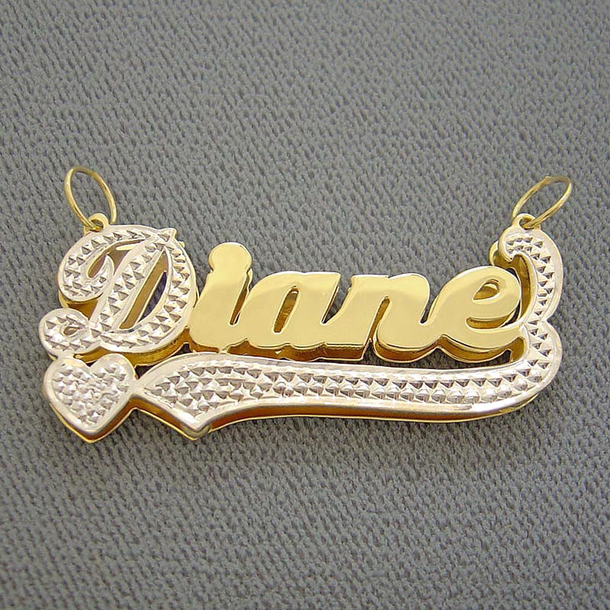 Close-up of 10K solid yellow gold custom 3D name charm showing rhodium white gold diamond-accented tail.