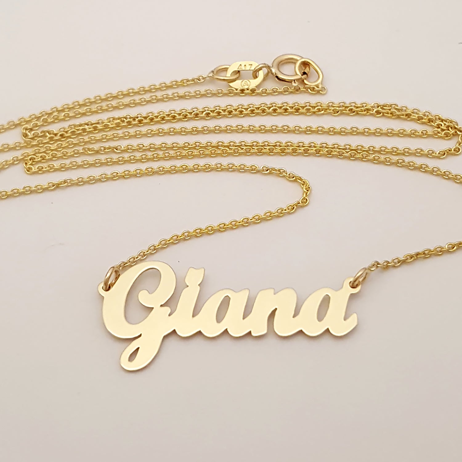 Close-up detail of handcrafted 10k yellow gold custom script nameplate pendant.