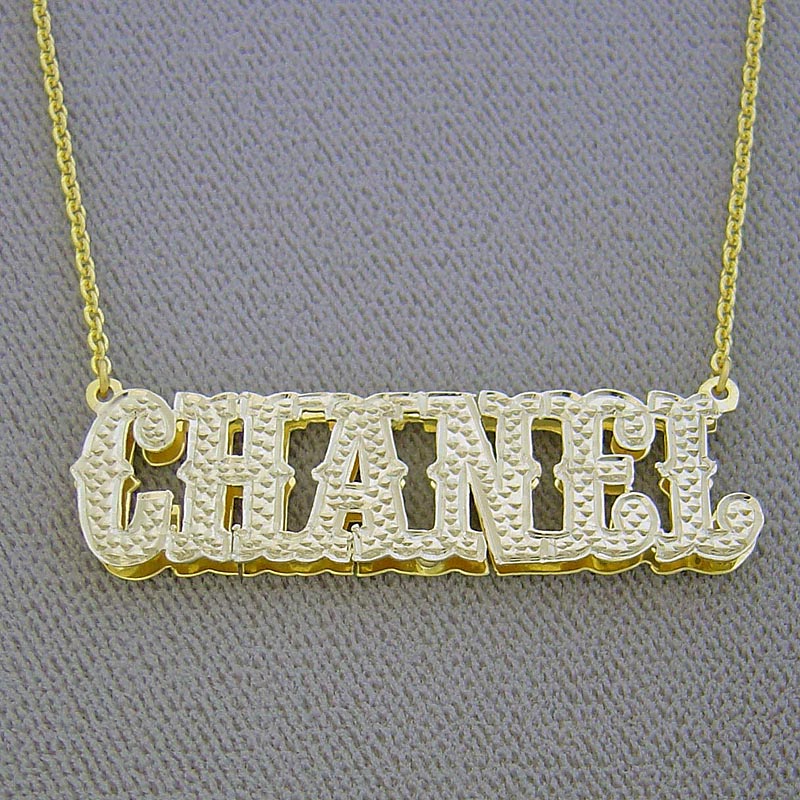 Side view detail of custom 3D double plate solid gold nameplate showing layered depth and rhodium diamond cutouts.