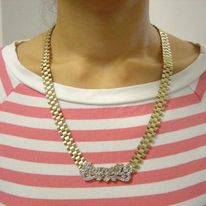 Woman wearing personalized 10K yellow gold 3D iced out Jeanette nameplate necklace with 10mm watch-band chain