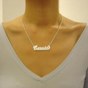 Custom sterling silver 3D cursive name necklace worn around the neck with a gold-tone top.