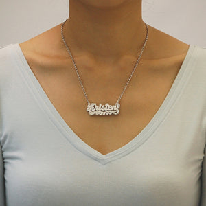 Woman wearing a personalized 3D double plate sterling silver nameplate necklace with a V-neck shirt.