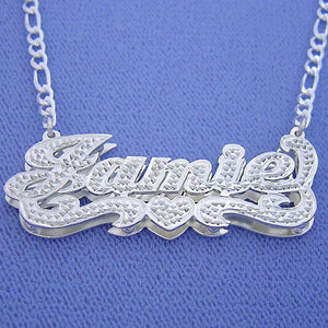 Handcrafted 925 sterling silver personalized 3D nameplate pendant attached to a solid Figaro chain, displaying custom cursive nameplate design with heart detail.