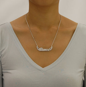 Model wearing the personalized sterling silver double plate angel wings nameplate necklace attached directly to a chain for a balanced fit.
