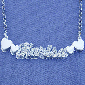 Personalized sterling silver 3D double plate nameplate pendant spelling "Marisa" with side heart accents and diamond detailing.
