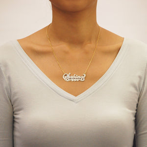 Model wearing custom 10K two-tone solid gold 3D name necklace with layered plate design.