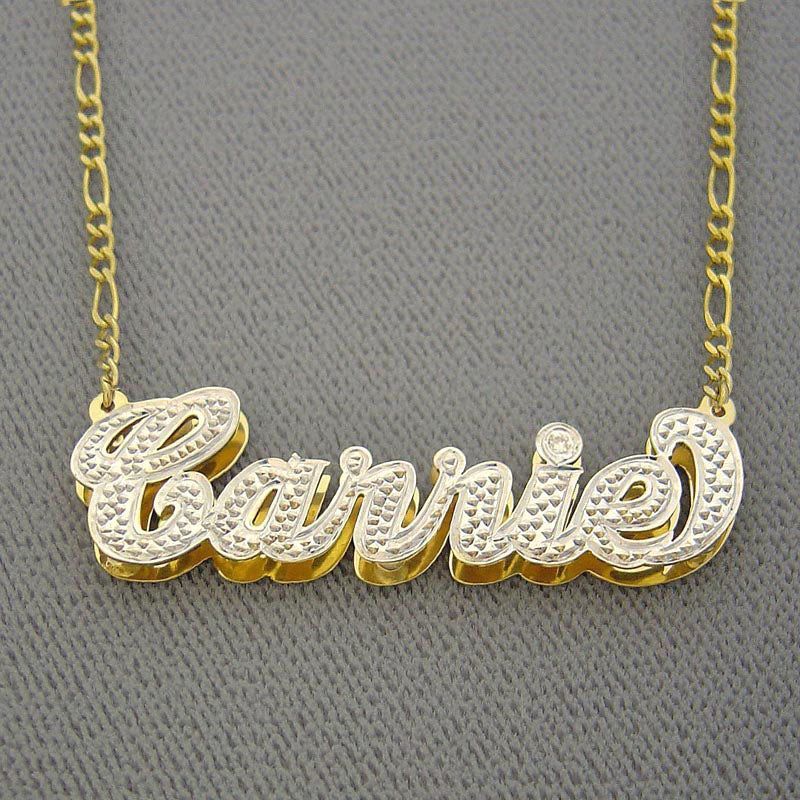 Close-up view of a custom solid gold 3D layered nameplate pendant showing hand-polished edges and white-tone diamond cut accent details.