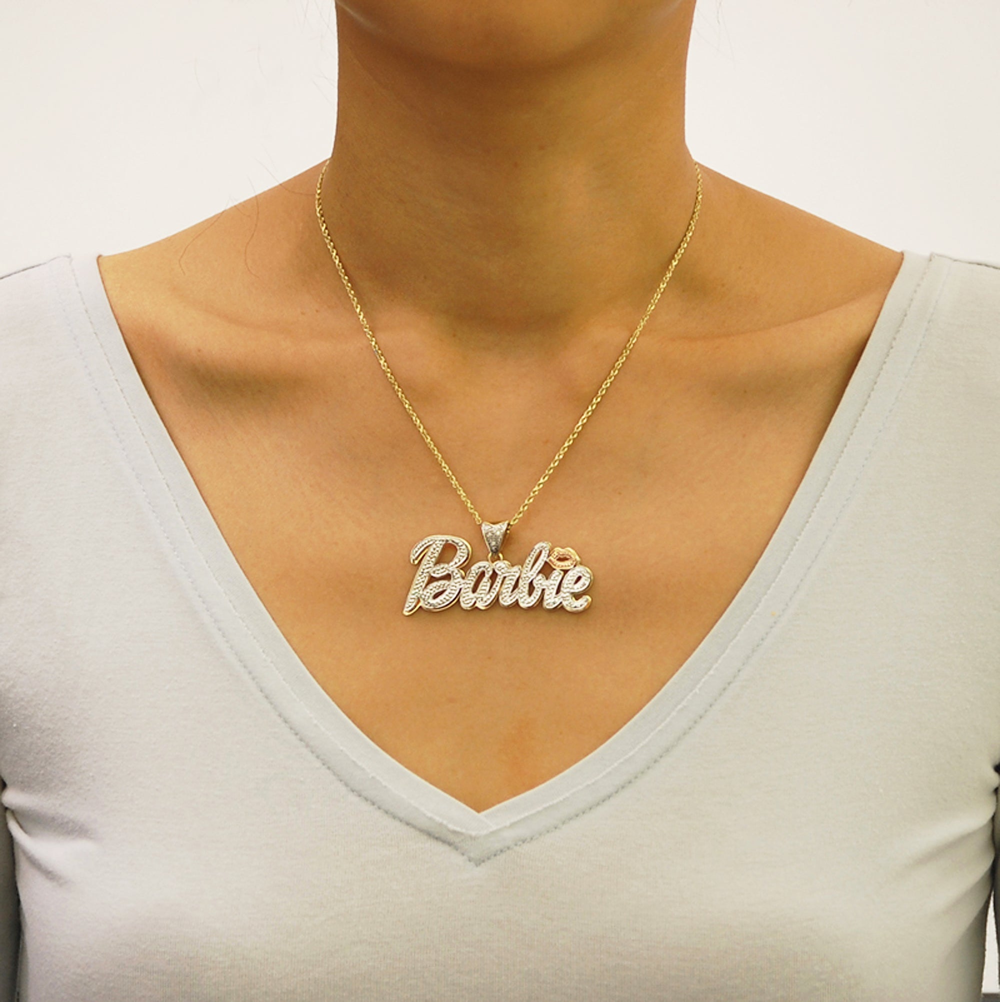 Woman wearing a custom personalized gold Barbie nameplate pendant necklace with a 16-inch gold chain.