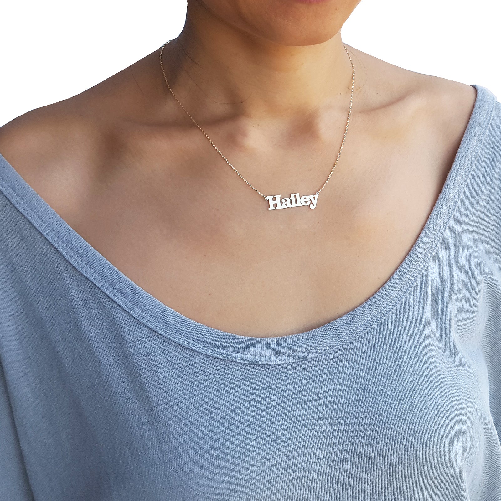 Model wearing a personalized small solid gold block name necklace.