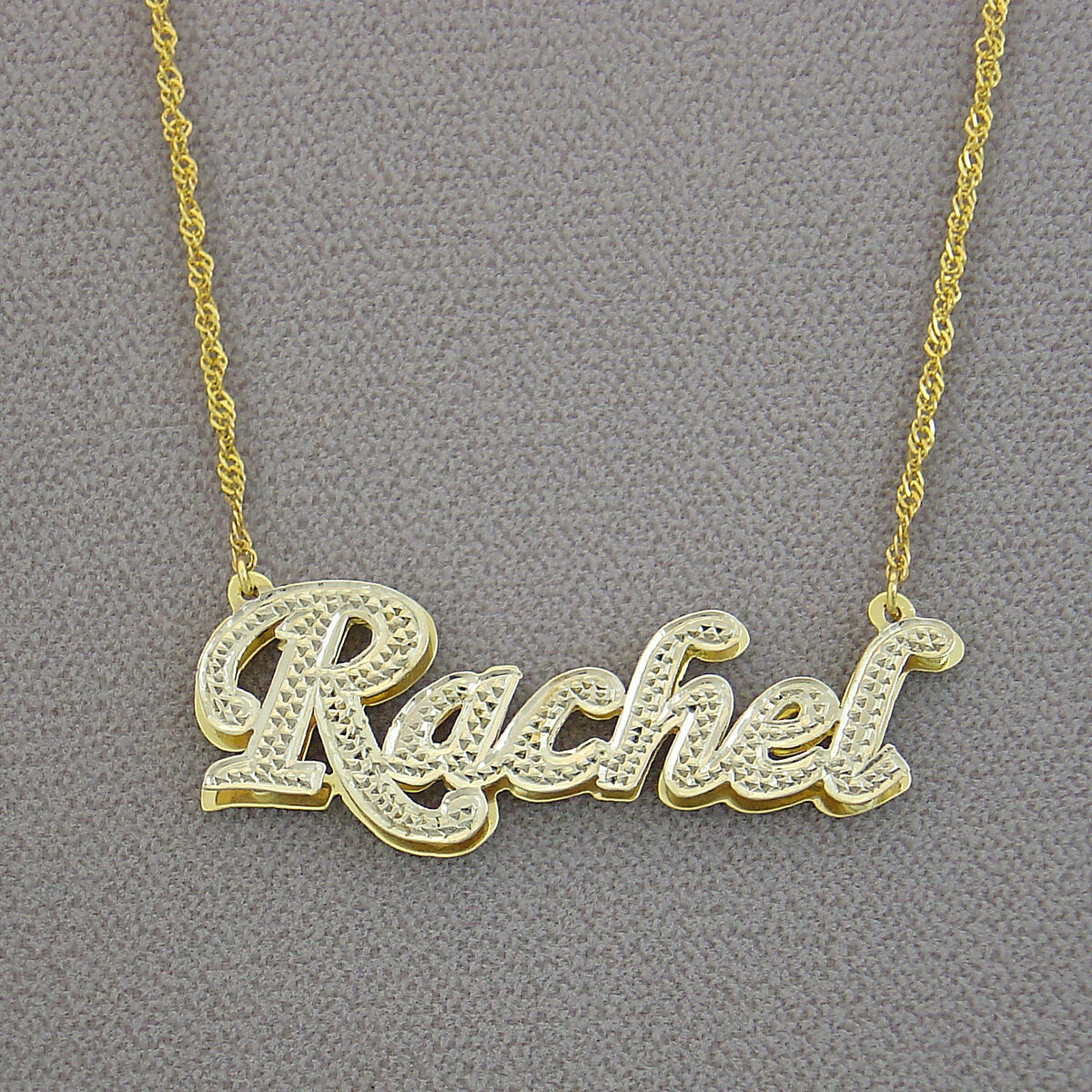 Back view showing the solid gold double plate backing construction of the custom 3D name pendant.