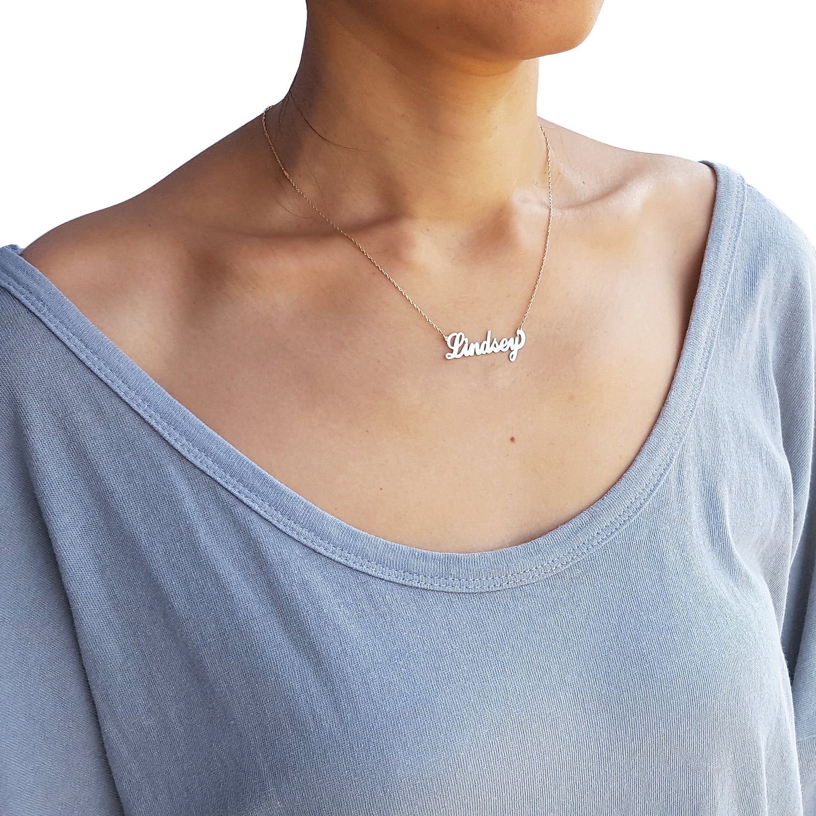 Woman wearing a delicate small gold script name necklace