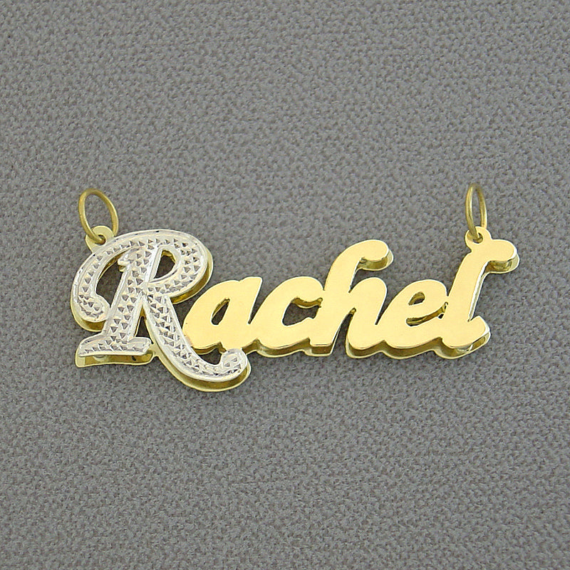 Close-up detail of a 3D double-plate gold name pendant showing diamond-carved top accents and polished backing.