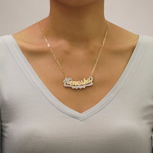 Custom solid gold double plate 3D name pendant shown attached to a gold Figaro chain