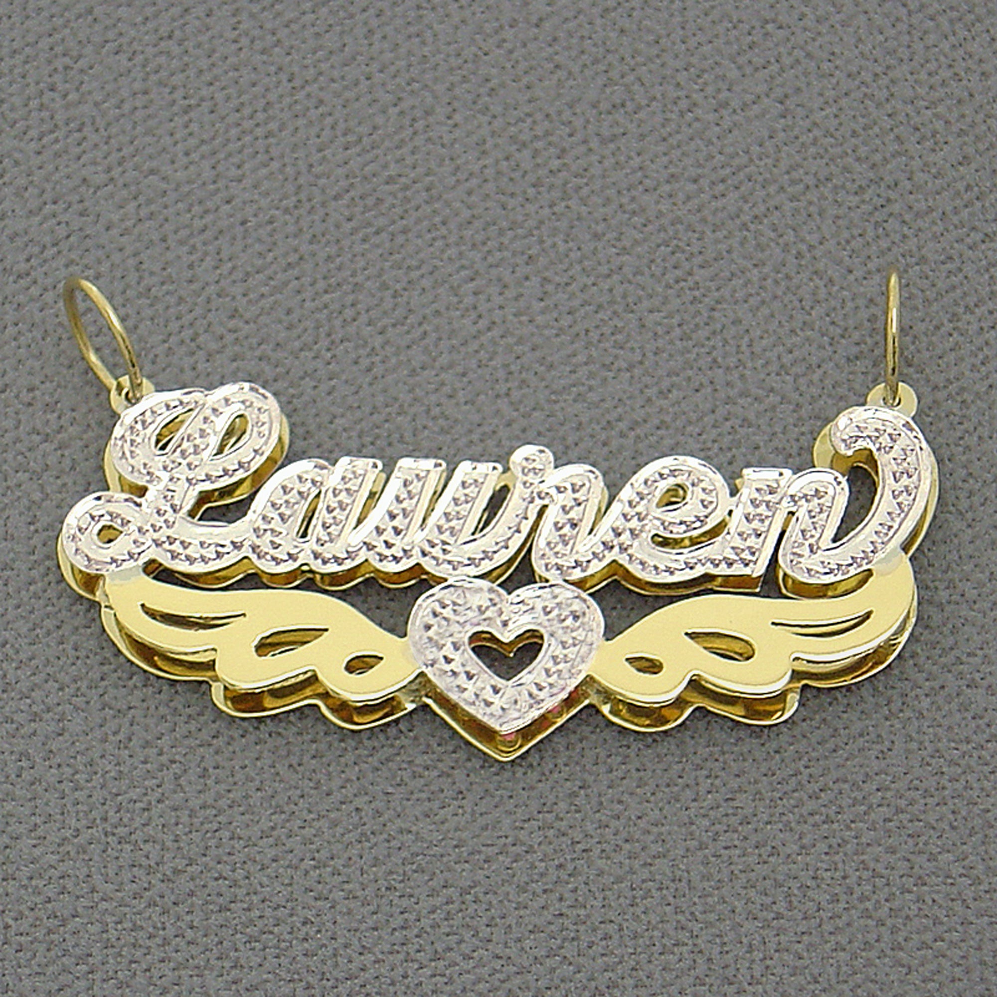 Close up of hand carved iced out white rhodium diamond accents on custom 14k two tone nameplate pendant.