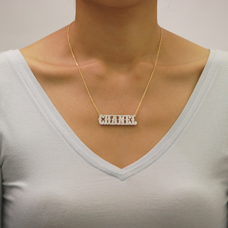 Model wearing custom 3D iced-out solid yellow gold name pendant necklace in Western cowboy font.