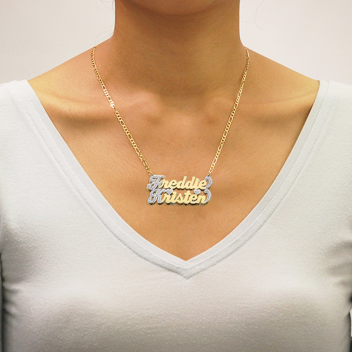 Model wearing the personalized 10K/14K gold double-plate couple name pendant on an 18-inch Figaro chain.