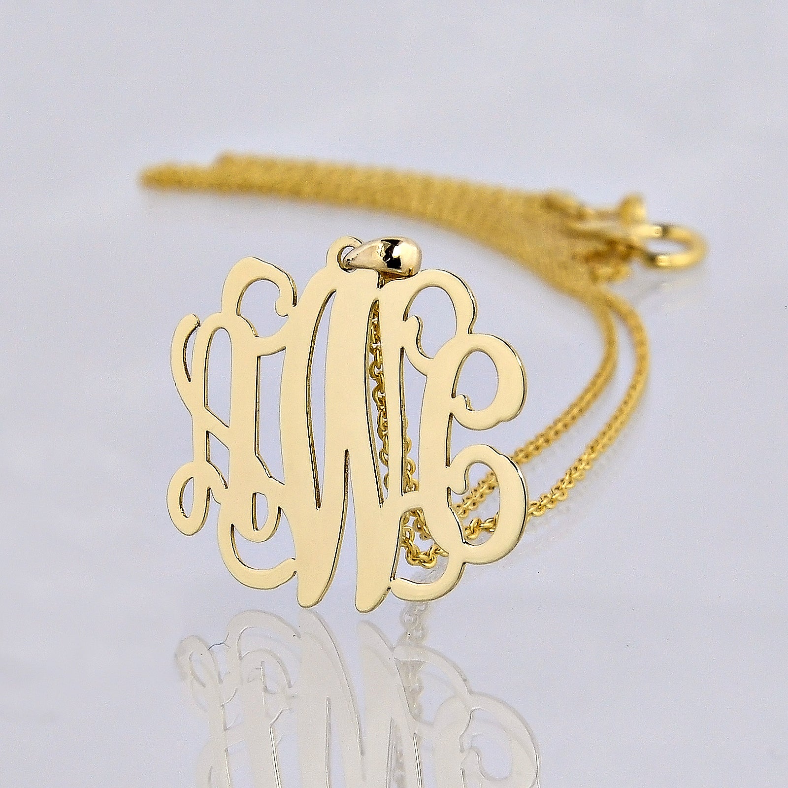 Small 14k yellow gold three-initial script monogram pendant necklace with polished reflective detail