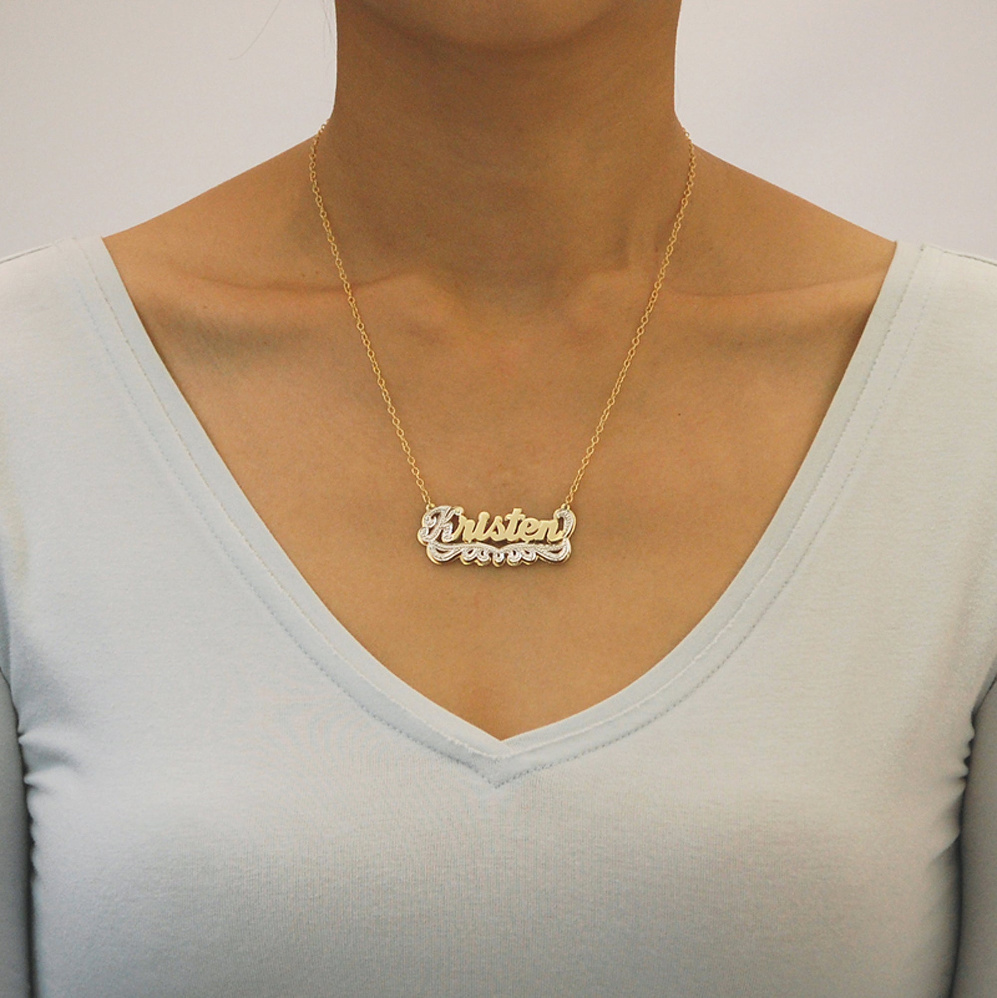 Back view of a solid 10K yellow gold custom double-layered name charm showing authentic USA quality hallmarks.