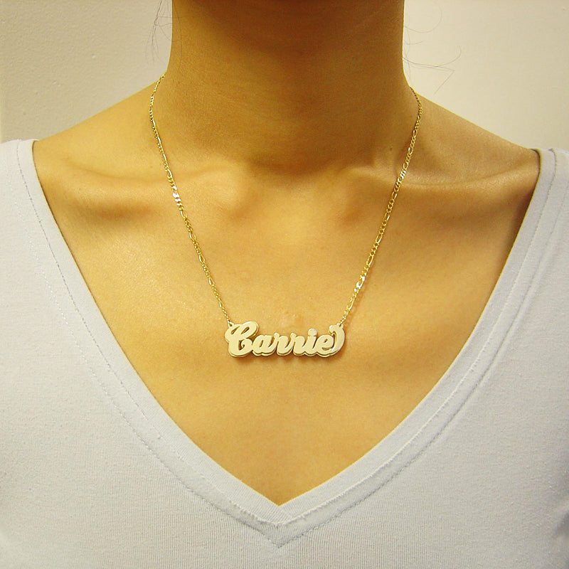 Woman wearing a custom 10K solid gold 3D double plate cursive nameplate necklace paired with a gold figaro chain.