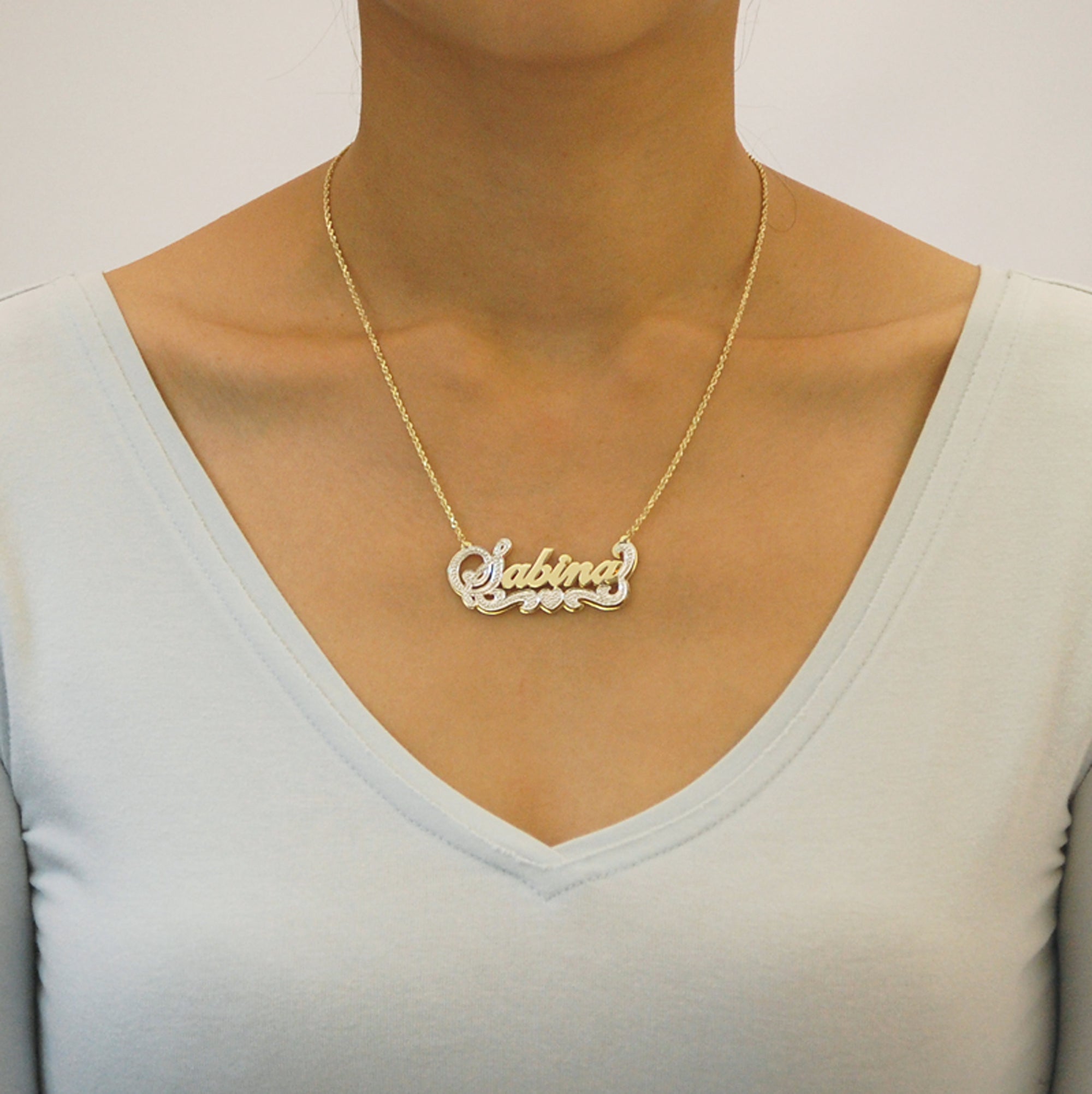 Model wearing a personalized 3D solid gold double plate nameplate necklace.