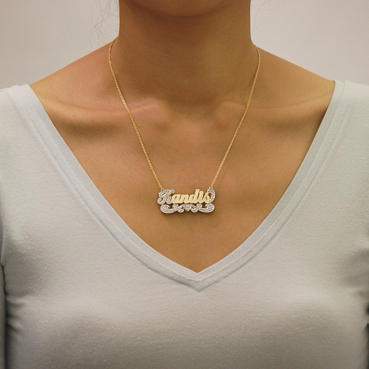Model wearing the personalized 3D two-tone gold nameplate necklace with a gold rolo chain.